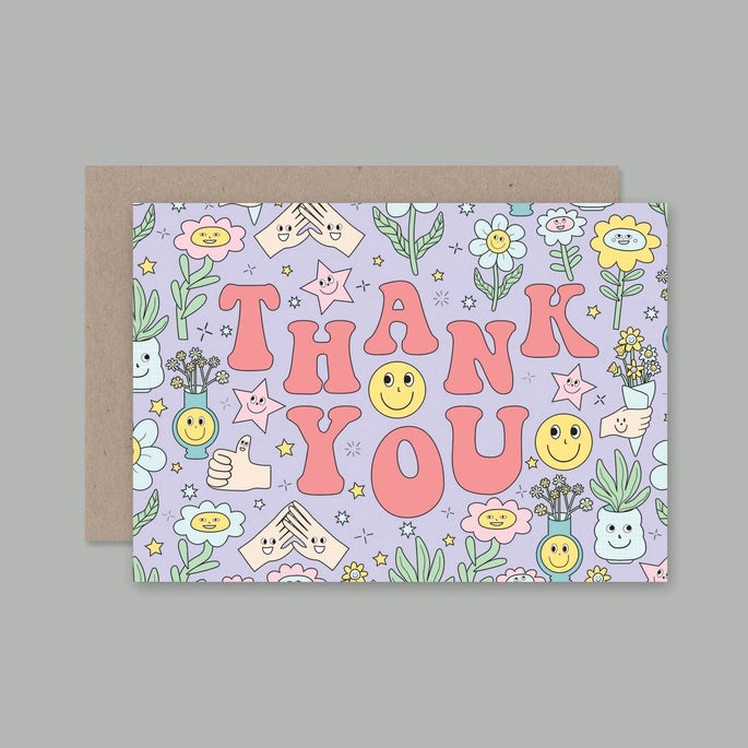 A colorful thank you card with floral and smiley face patterns, the words 'THANK YOU' in bold letters, and a brown envelope behind it.