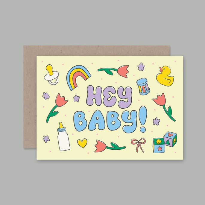 A colorful greeting card with the text 'Hey Baby!' featuring a cartoon baby bottle, a rainbow, flowers, and an illustration of a bird.